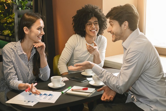 three young millenniials working at a conference table