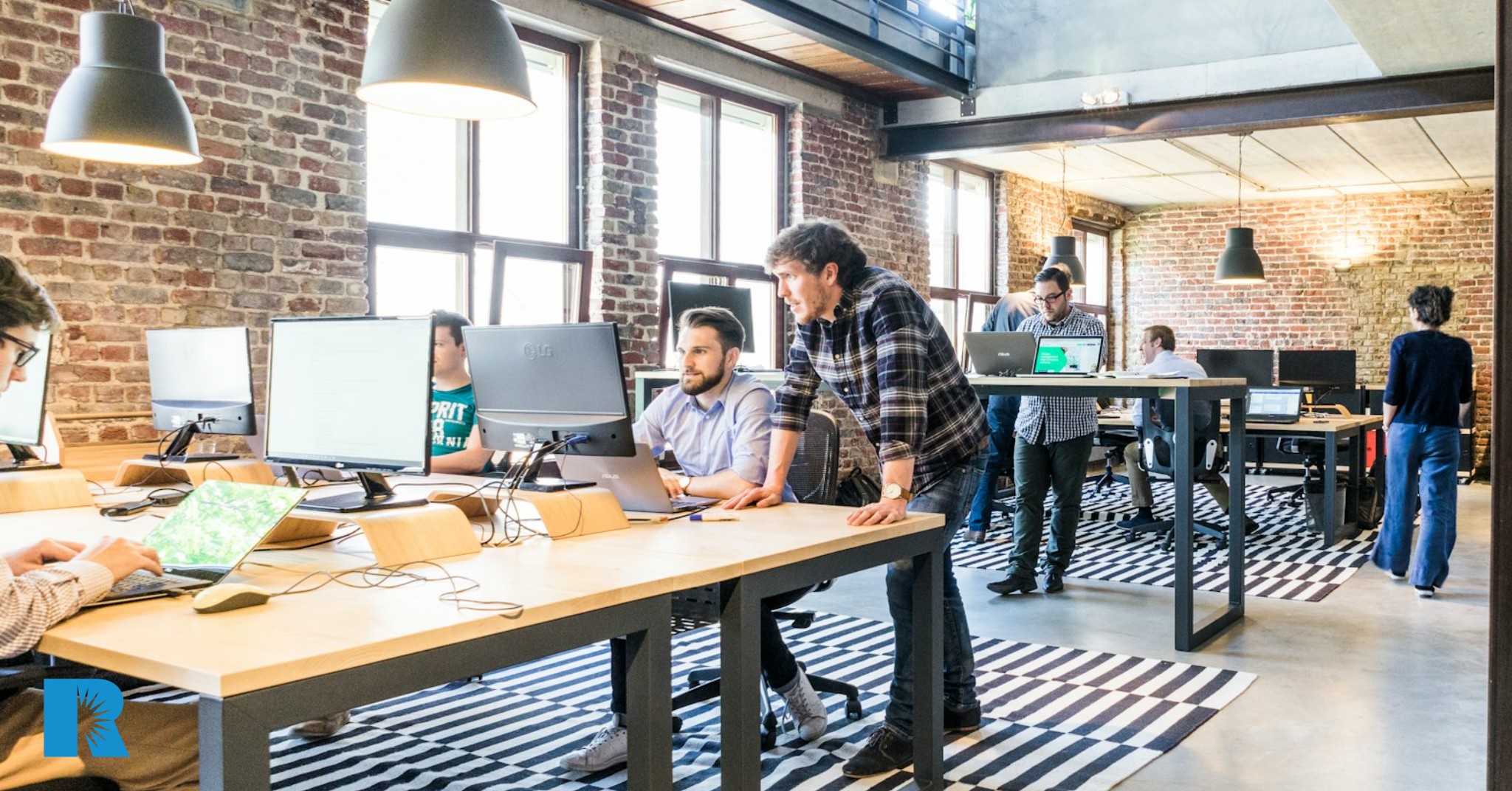 Agents work at their desks at the office of a busy insurance agency.