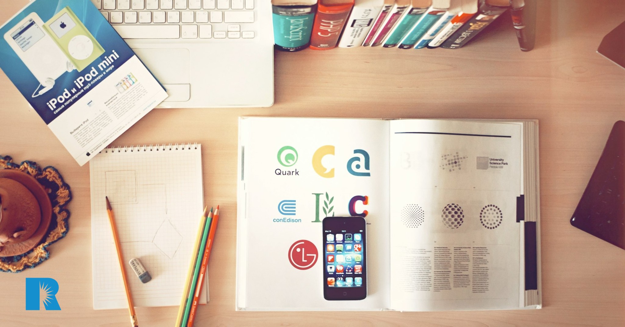 A desktop strewn with marketing materials and a cell phone.
